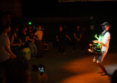 Crabe Vert devant un public qui danse : toutes les personnes sont masquées.